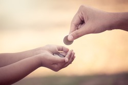 Mother giving coin to child as saving money concept in vintage color tone