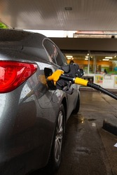 Pumping gasoline fuel in car at gas station. Car refueling fuel on petrol station. Service is filling gas or biodiesel into the tank.