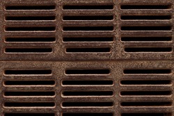 Texture sewage grid background: city street brown old rusty metal iron gutter. Dark drain sewerage grate for waste and rain water