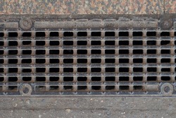 Texture sewage grid background: brown old rusty metal iron gutter. Dark drain sewerage grate for waste and rain water