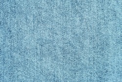 Texture background: trendy light blue denim cotton fabric, jean clothing, clothes textile. Jeans tissue with white color