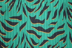 Decorative background texture: green silk pleated fabric. Turquoise tissue with bird feathers, dress textile with folds. Chiffon cloth, wild exotic tropical pattern with black tiger stripes