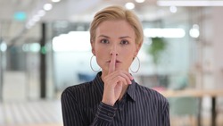 Portrait of Young Businesswoman Putting Finger on Lips, Quiet Sign 