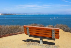 An empty bench sits overlooking San Diego bay on the Bayside Trail at Cabrillo National Monument in Point Loma, California.