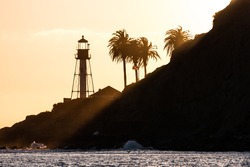 Sun rays shining on the new Point Loma lighthouse at sunset in San Diego, California.  