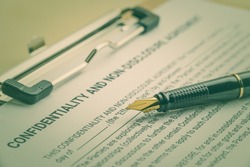 Business legal document concept : Fountain pen on a confidentiality and non disclosure agreement form. Confidentiality agreement is a legal contract between 2 parties that outlines confidential issues