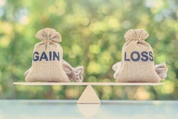 Capital investment gain and loss, financial concept : Gain and loss bags on a basic balance scale, depicts balancing between profit and loss while managing assets e.g bonds, stocks, derivatives, ETFs