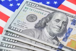 Safe-haven currency for investment, financial concept : US 100 USD dollar banknotes on a flag of USA, depict most popular asset for central bank reserve / global money for using or paying in the world