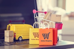 Online shopping, logistics, supply chain and shipment service, e-commerce concept : Paper bags, boxes of goods, trolley, delivery van on a laptop, depicts customers uses internet to order  buy things