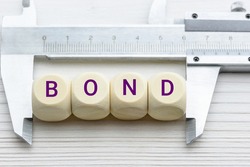 Bond market and bond issue size, financial and investment concept : A vernier caliper measures 4 square cubes with a word BOND, depicts measuring market size of bond e.g junk, government, corporate