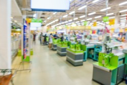 Blurred image of supermarket / hypermarket checkout counter or point of sale (POS) or point of purchase (POP) with cash register. Customers can make a payment in exchange for goods or service here.