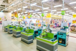 Blurred image of supermarket / hypermarket checkout counter or point of sale (POS) or point of purchase (POP) with cash registers. Customers can make a payment in exchange for goods or service here.