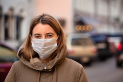 Woman wearing face mask during coronavirus outbreak. Virus spread flu prevention carantine. Girl in a facemask on a streets of Italy