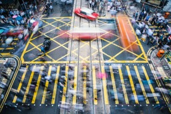 People and taxi cabs crossing a very busy crossroads in the central district, Hong Kong, China