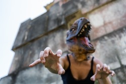 Halloween fear horror concept.Female in lizard mask gesturing with hands at camera