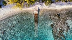 a Peer that is old and go down its on a beautiful beach in the tuamoto in French Polynesia view from the top make whit Drone 