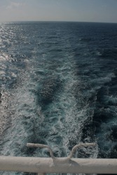 View from the aft deck, the view of foamy waves made by the propeller of a merchant ship at sea