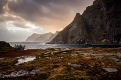Å i Lofoten in Northern Norway, mountains, blue sea, clouds and pink sky, wind, waves, in autumn, in Lofoten Islands archipelago, dramatic atmosphere