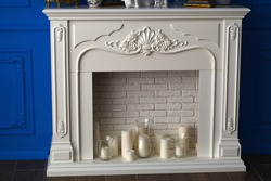 White fireplace in the room and white candles