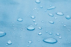 non woven fabric water texture background Water drops on waterproof nylon fabric Macro detail view of texture of blue woven synthetic waterproof clothing Waterproof fabric with water drops Rain Drops