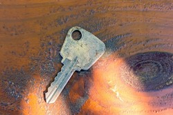 Old-fashioned lock key on a wooden table. Metal key.