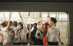 Many people on the train wear anti-virus masks and travel during rush hours. business asian man on sky train.