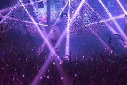 Light Show And Silhouette hands of audience crowd people use smart phones enjoying the club party with concert.  Blurry night club DJ party people enjoy of music dancing sound.Abstract Background.