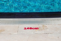 emoticon showing depth in front of a swimming pool. 140 cm pool depth mark.