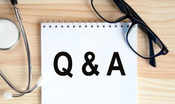 Q and A - Questions and Answers - sign through magnifying lens in doctor hands, medical questions concept