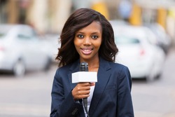 happy female african news reporter working outdoors