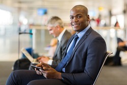 handsome african business traveler using tablet pc at airport