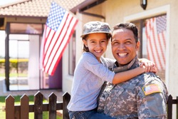 portrait of us army soldier and little daughter outside their home