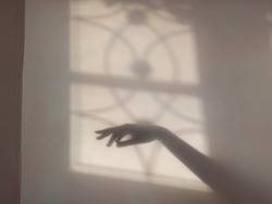 An aesthetic blur shadow of the hand in the wall