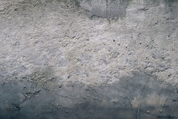 Textured concrete wall with gradient from light to dark grey, scuffed and smudged with cement. Grunge texture and background concept.
