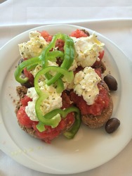 Greek food dakos salad tomatoes feta cheese olives pepper bread