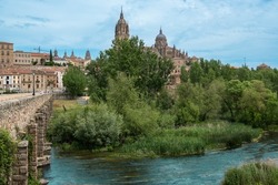 Bridge of Roman origin over the Tormes River as it passes through the city of Salamanca with its sixteenth-century Gothic cathedral in the background, Spain