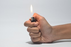 Cropped Hand Igniting Cigarette Lighter Against White Isolated Background 
