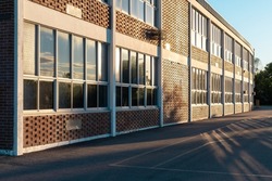 School building and school yard in the evening with sun reflecting in the windows of the build structure