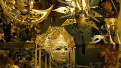 Richly decorated display case. Golden carnival masks, faces covered with mother-of-pearl and pallets.  