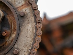 Gear, detail of an old combine. Rusty metal gear with chain.