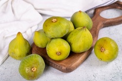 Fresh figs. Ripe figs in a wooden serving dish on a stone background. Bulk figs. close up