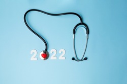 2022 wooden number with stethoscope. Happy New Year for heart health and medical concept, life insurance business, New Year resolutions goal. High quality photo