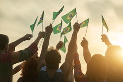 Rising up brazil flags. Crowd of people holding brazilian flags, back view.