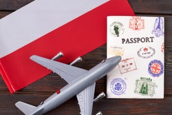 Flight to Poland concept. Toy passanger airplane with passport and flag of Poland flat lay top view.