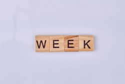 Week word made with wooden cubes and black letters. Isolated on white background.
