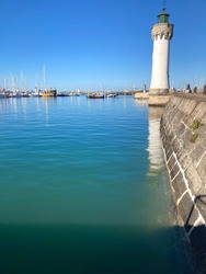 View on Port Haliguen, Quiberon in Brittany, sky and sea are so blue, we can see the lighthouse and its reflection in the ocean