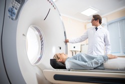 Doctor doing computed tomography for female patient stock photo. Medicine diagnostic concept