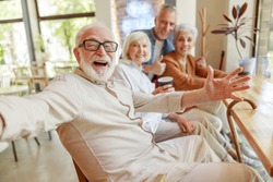 Joyful senior man spending time with friends stock photo