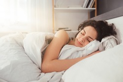 Feeling calmness. Sleepy female keeping eyes closed while dreaming about future vacation or sleeping at the bedroom. Stock photo
