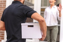 courrier delivering a box to the happy woman
